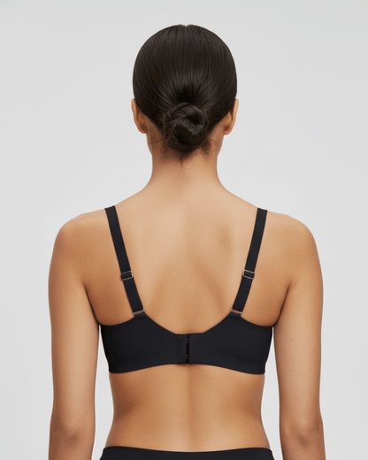 Woman wearing black wireless bra, back view showing adjustable straps and hook closure