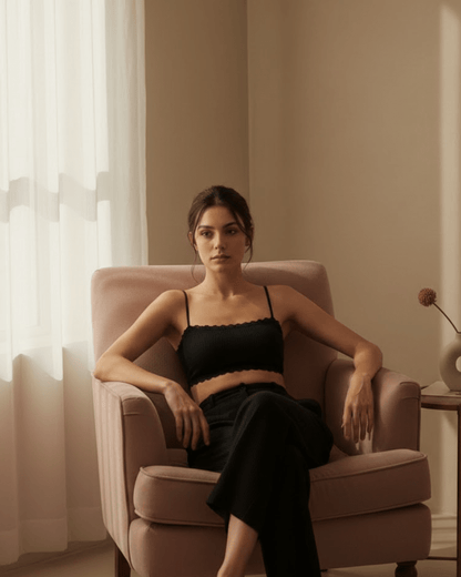 Woman wearing black seamless wireless cotton bra sitting in a cozy armchair