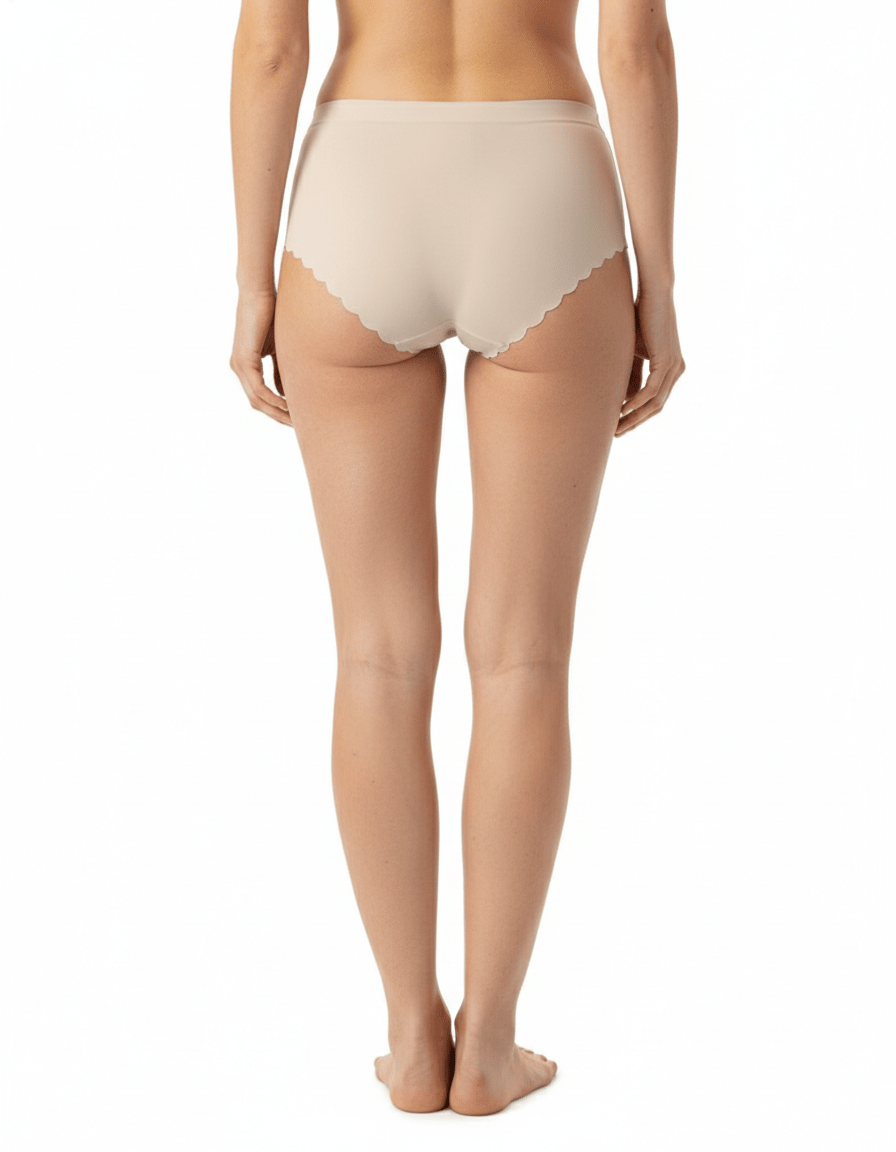 Seamless nude no-show panties with scalloped edges, shown on a model from the back.