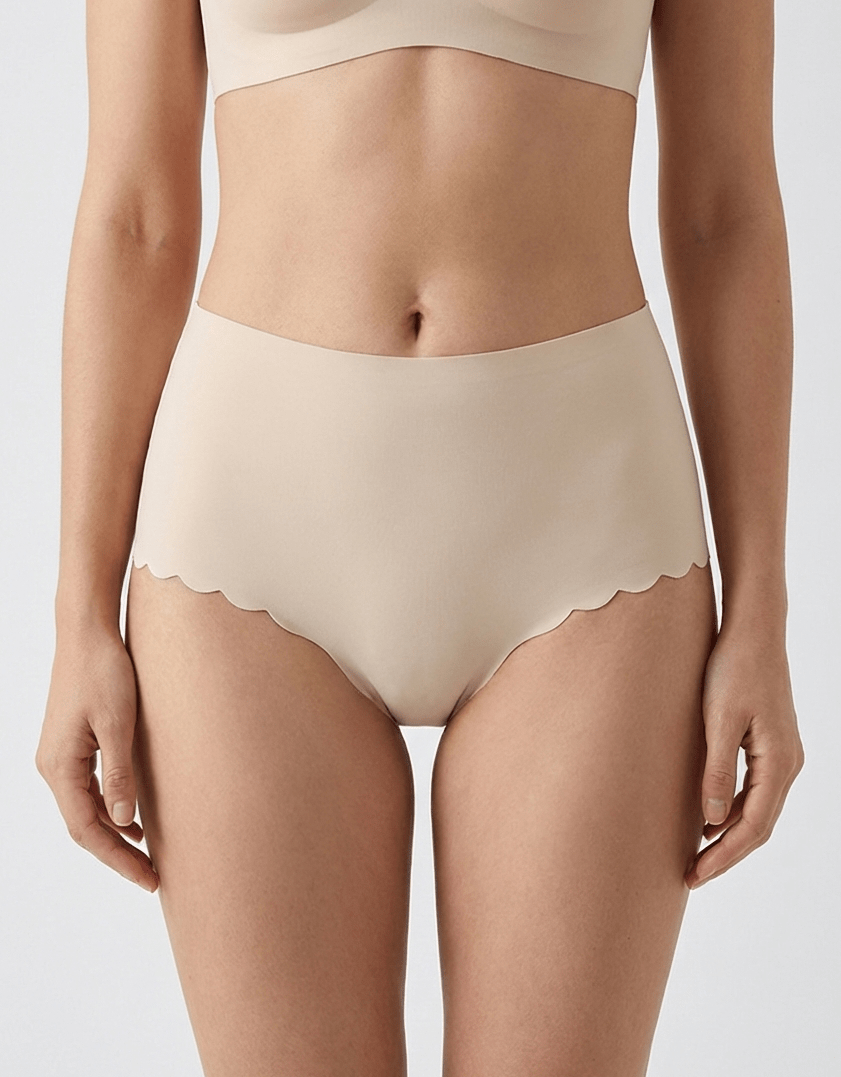 Seamless nude no-show panties with scalloped edges on a woman, invisible under clothing